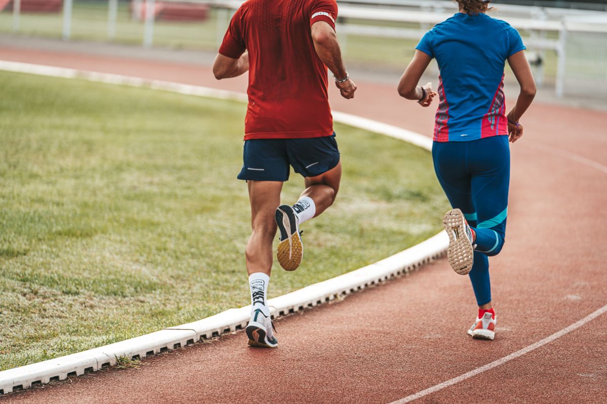 Un homme et une femme courant sur une piste d'athlétisme
