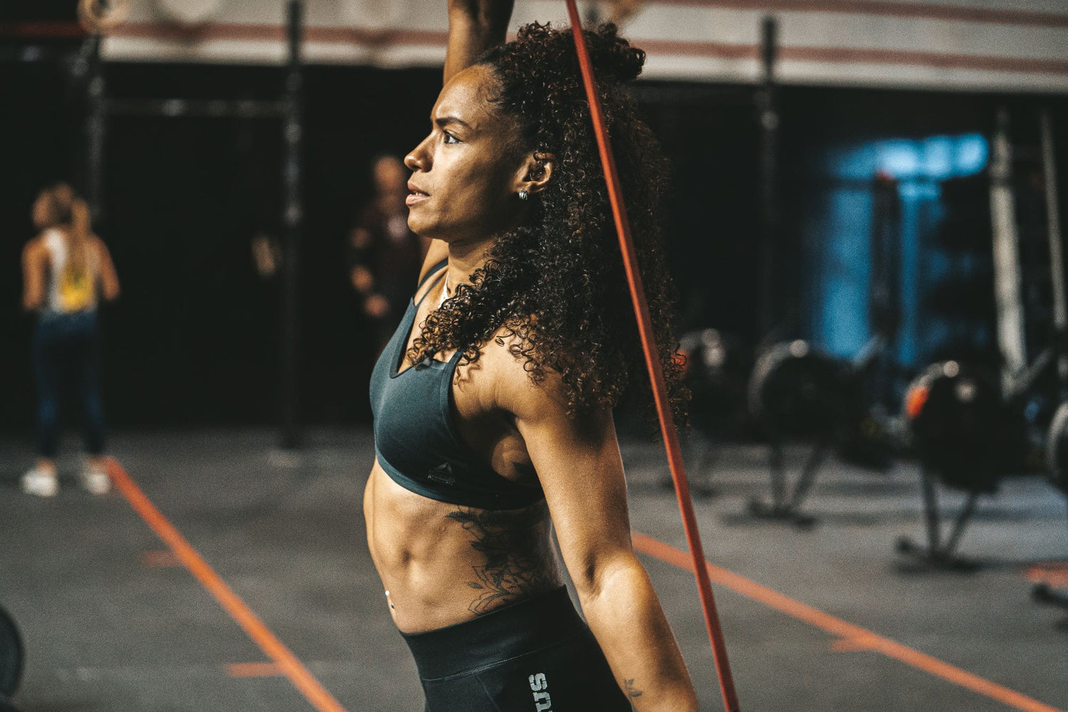 Photo de femme s'étirant avec un élastique avant son entraînement sportif dans une salle de sport