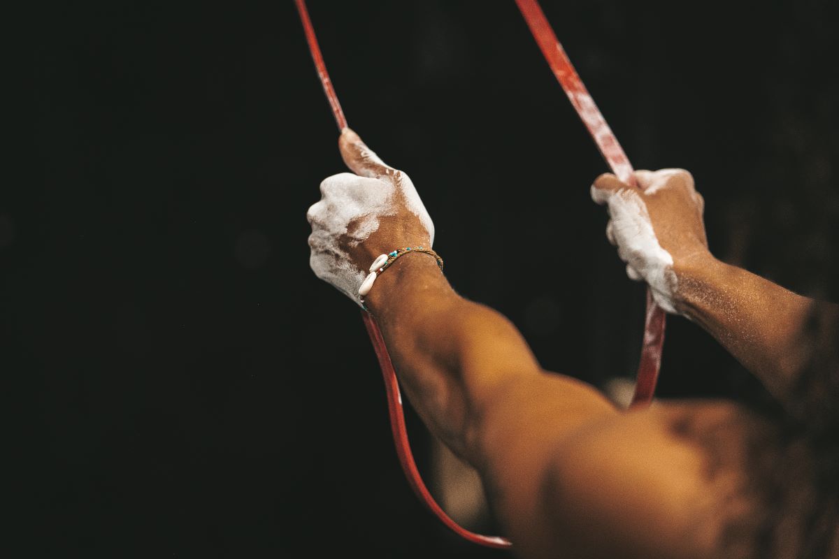 mains couvertes de magnésie tirant un élastique de sport