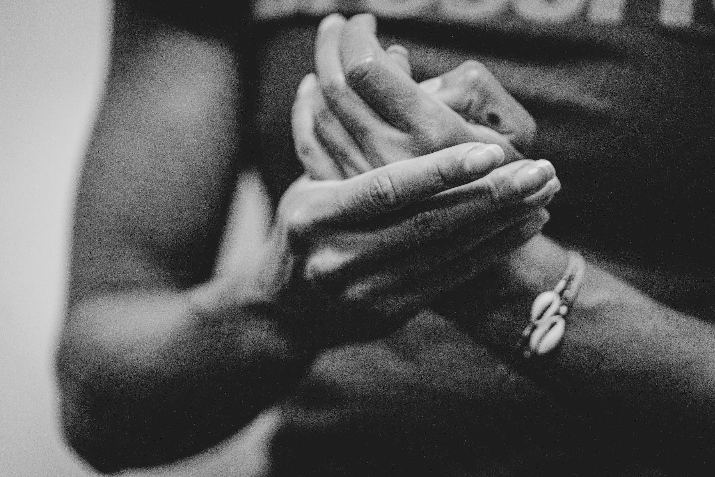 Photo en noir et blanc de mains de sportive en train d'appliquer de la crème sur ses mains