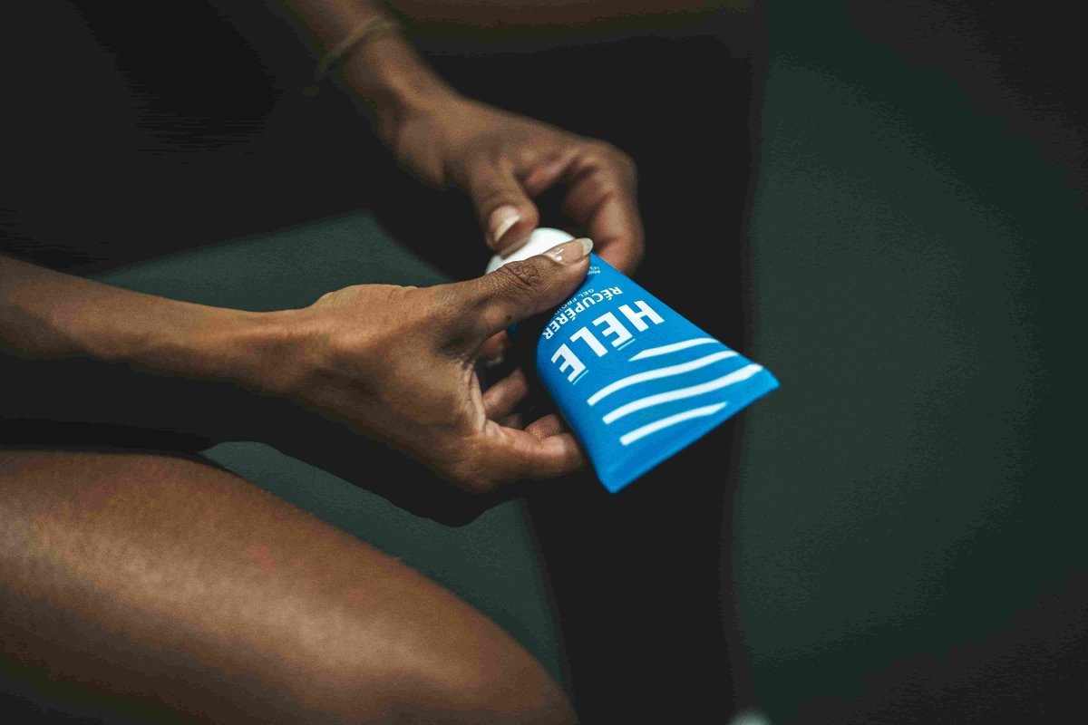 Gros plan sur les mains d'une sportive ouvrant un tube de gel cryo froid Récupérer de la marque HELE