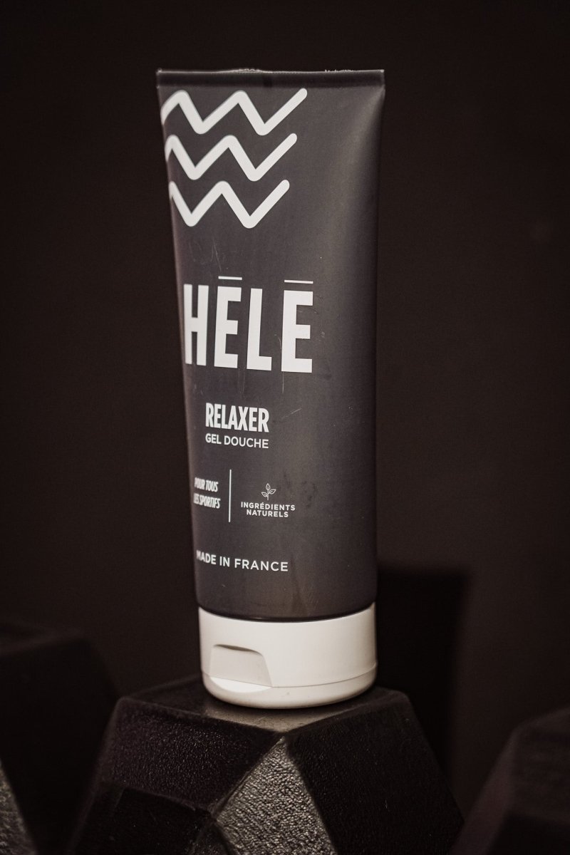 Tube de gel douche sport Relaxer de la marque HELE posé sur un haltère noir