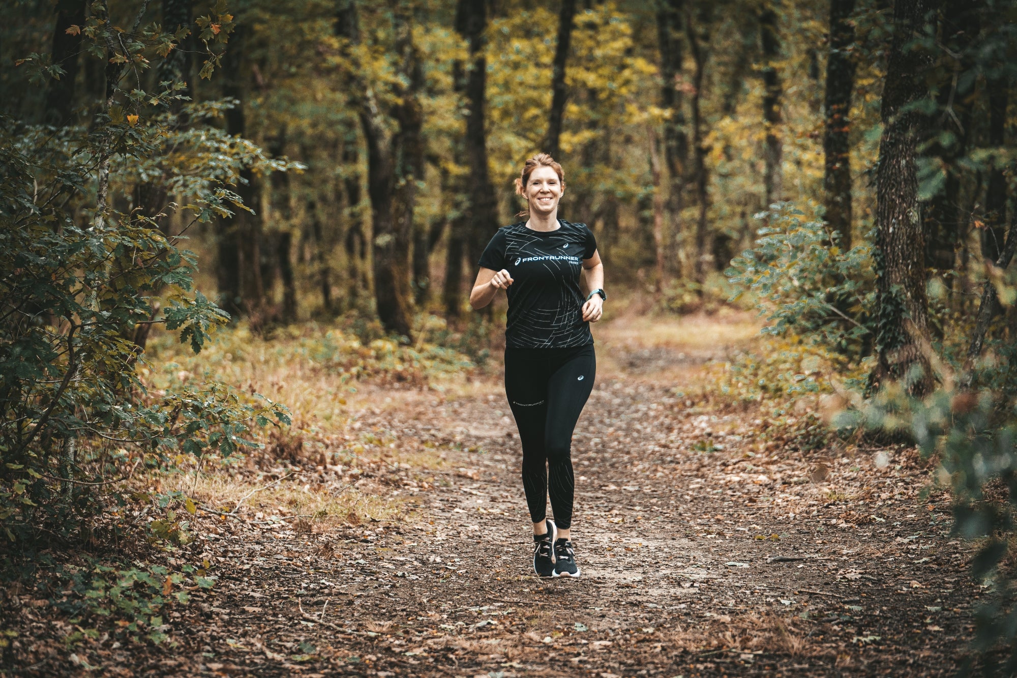 La sportive Julie Amiel en train de courir sur un sentier en forêt