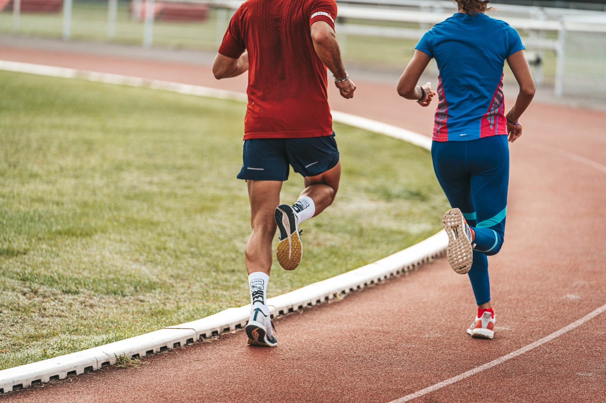 Objectifs sportifs - Deux sportifs de dos courant sur une piste d'athlétisme