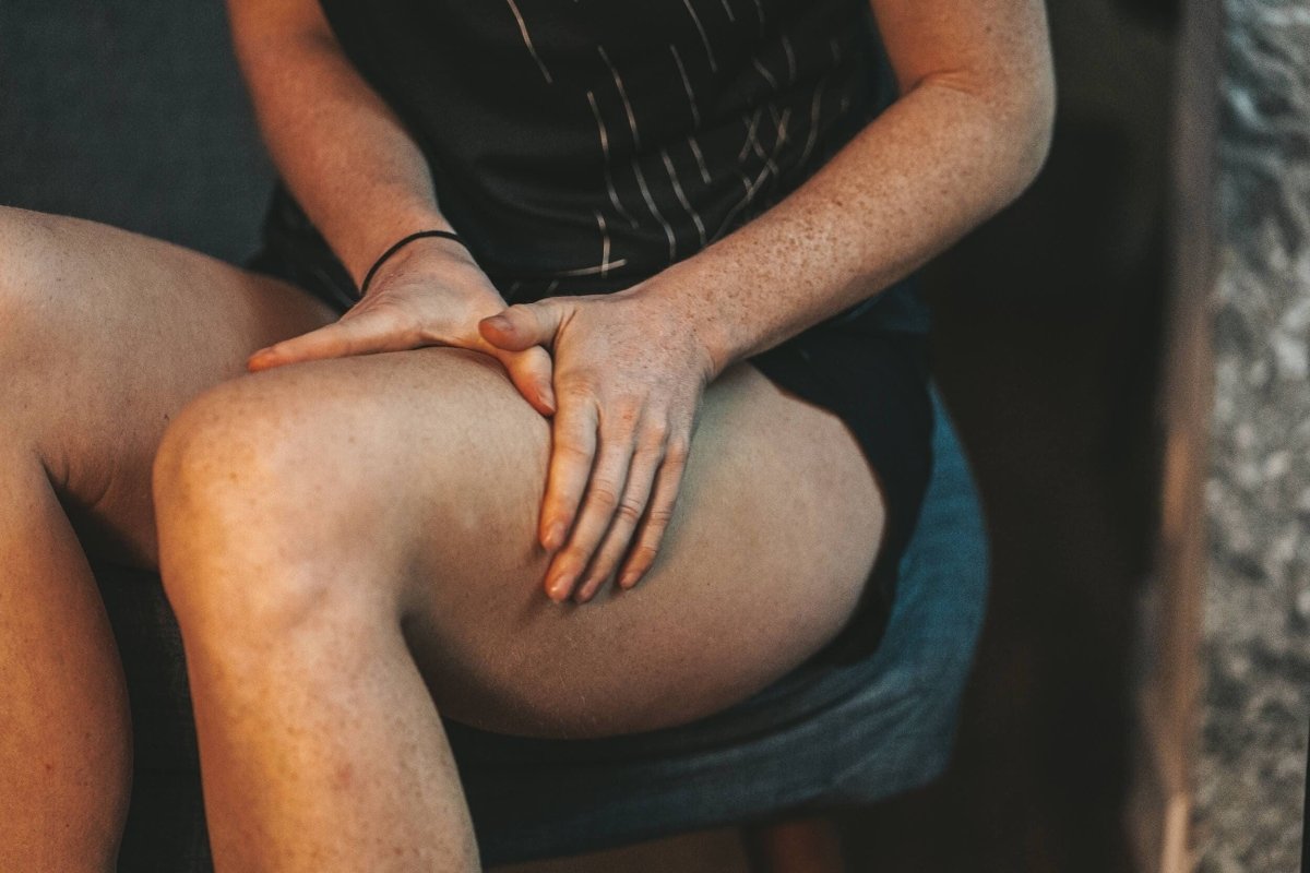 Gros plan sur la cuisse d'une sportive en train de se masser les jambes