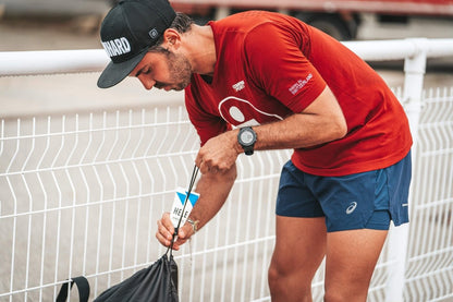 Le triathlète Benjamin Vallée sort de son sac de sport un tube de gel articulaire Renforcer de la marque HELE